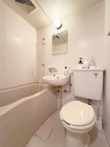 a white bathroom with a toilet and a sink at The Inui N3 in Tokyo