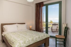 Agia MarinaにあるFagias Luxury Apartmentのベッドとバルコニーのある寝室