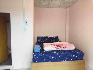 a small bedroom with a bed with a blue sheets at Rai Saeng Mek ไร่เเสงเมฆ in Ban Maeo Thap Boek