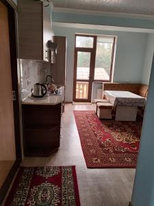 a kitchen and living room with a bed and a rug at Квартира in Samarkand