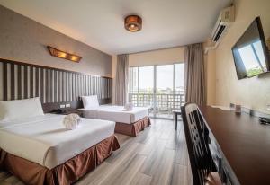 Una habitación de hotel con dos camas y balcón. en Sunday JA Plus Hotel, en Pattaya central 87 fotos más
