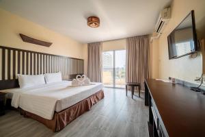 a hotel room with a bed and a television at Sunday JA Plus Hotel in Pattaya +85 photos