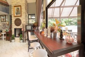 a living room with a long wooden counter with chairs at Capital O 75378 Thawapee Resort in Rayong