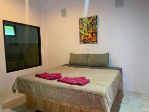 un lit dans une chambre avec deux oreillers rouges dessus dans l'établissement OYO 75524 SK Resort, à Ban Khuan Yung