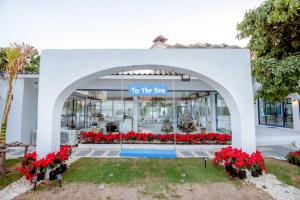 un bâtiment blanc avec un panneau indiquant la sape dans l'établissement Collection O To The Sea Resort Thailand, à Na Jomtien