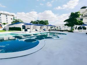 - une piscine d'eau bleue avec des parasols bleus dans l'établissement Collection O To The Sea Resort Thailand, à Na Jomtien 75 autres photos