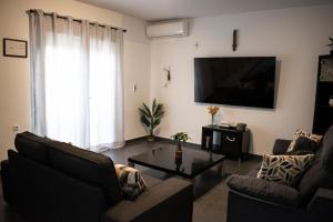 a living room with two couches and a flat screen tv at Domus Citrus in Merida