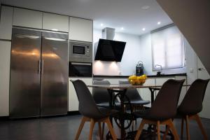 a kitchen with a table and a stainless steel refrigerator at Domus Citrus in Merida