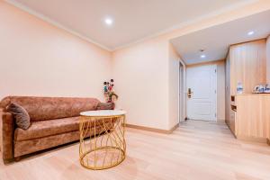 a living room with a couch and a table at Palette The Travellers Hotel Bangkok in Bangkok