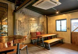 a restaurant with tables and a painting on the wall at Episode 11 Hostel Sukhumvit in Bangkok