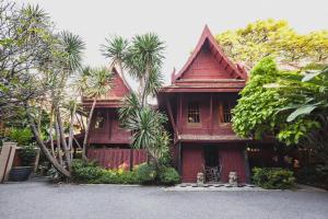 a red house with palm trees in front of it at Episode 11 Hostel Sukhumvit in Bangkok
