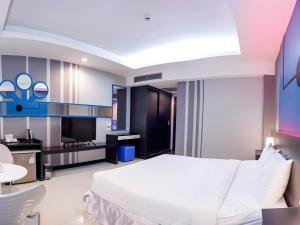 a bedroom with a white bed and a tv at Marian Kisad Hotel in Baguio