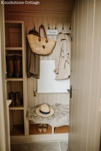 a walk in closet with clothes and a hat at Lyme Tree Farm Cottages - Hotching Barn and Knockstone Cottage in Tideswell +78 photos
