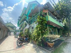 una motocicleta estacionada frente a un edificio en Hotel O Villa Thai, en Pantai Cenang