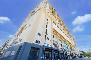 a tall white building with a pointed roof at Hotel O Destiny Riverside Hotel in Kota Bharu