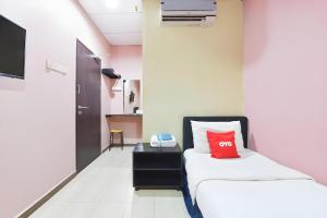 a room with a bed with a red pillow on it at Hotel O Destiny Riverside Hotel in Kota Bharu +80 photos