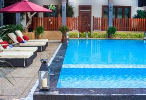 een zwembad met stoelen en een fles ernaast bij Sunday Telaga Terrace Boutique Resort in Pantai Cenang