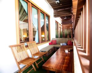 a porch with two chairs and a table and a couch at Sunday Telaga Terrace Boutique Resort in Pantai Cenang