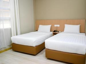 Letto o letti in una camera di Capital O 89344 Labuan Avenue Hotel
