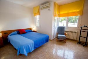 a bedroom with a blue bed and a chair at Nature & Tranquility only 25km from Barcelona in Torrelles de Llobregat +81 photos