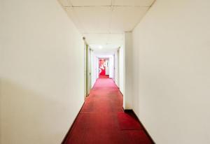 a corridor in an empty room with a red carpet at Hotel O My Hotel in Segamat