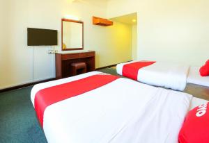 a hotel room with two beds and a mirror at Hotel O My Hotel in Segamat