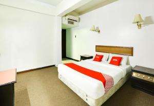 a bedroom with a large bed with red pillows at Hotel O My Hotel in Segamat