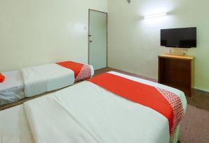 a hotel room with two beds and a flat screen tv at Hotel O My Hotel in Segamat +33 photos