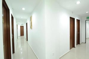 a corridor of a building with white walls and brown doors at OYO 1055 Batu Caves Star Hotel in Batu Caves