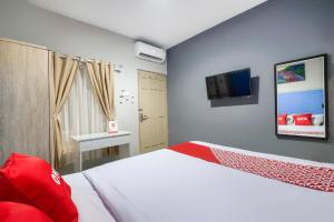 Hotel O Prambanan Near Prambanan Temple tesisinde bir odada yatak veya yataklar