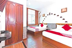 a bedroom with two beds and a desk in it at Hotel O Five 2 in Kota Kinabalu