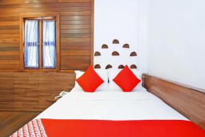 a bedroom with a bed with red pillows at Hotel O Five 2 in Kota Kinabalu