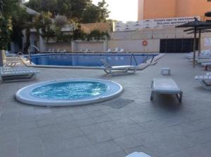 a swimming pool with a bench and a table at Alicante Hills 1 in Alicante