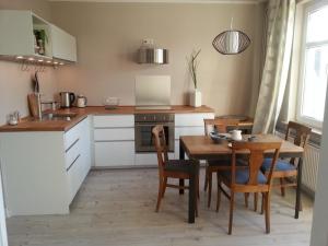 eine Küche mit Holztisch und ein Esszimmer in der Unterkunft Haus MeerZeit in Cuxhaven