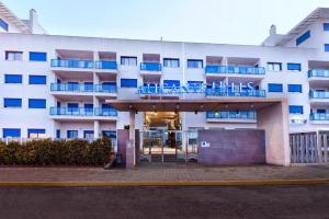a large white building with blue chairs in front of it at Alicante Hills 1 in Alicante