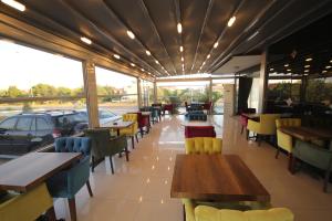 a restaurant with tables and chairs and a car outside at Alptekin Otel in Ürkmez