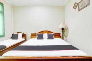 Postel nebo postele na pokoji v ubytování Hotel O Manahan Near Stadium Manahan Solo Formerly Atma Bhakti