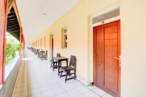 a corridor with chairs and a wooden door in a building at Collection O Stasiun Pekalongan Near Stasiun Kereta Api Formerly Hotel Indah in Pekalongan