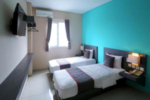 Postel nebo postele na pokoji v ubytování Super OYO Townhouse OAK Hotel Fiducia Pondok Gede