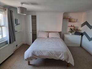 a bedroom with a large bed in a white room at Dunstans Retreat in Canterbury