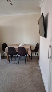 a room with a table and chairs and a flat screen tv at Dunstans Retreat in Canterbury