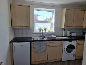 a kitchen with a sink and a washing machine at Dunstans Retreat in Canterbury +5 photos