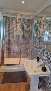 a bathroom with a shower and a white sink at Dunstans Retreat in Canterbury