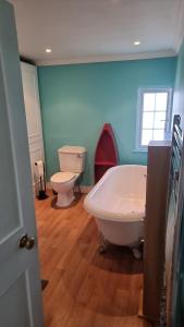 a bathroom with a white tub and a toilet at Dunstans Retreat in Canterbury