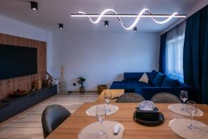 a living room with two tables and a blue couch at Apartament Centru Vechi in Târgovişte