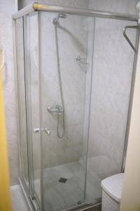 a shower with a glass door in a bathroom at Cozy Apartment Near The Beach in Kakhaberi