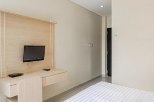 a bedroom with a bed and a tv on a wall at Collection O Kuta Near Airport Ngurah Rai in Kuta +33 photos