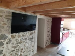 a stone wall with a flat screen tv on a wall at Magnifique Gite de charme in Seyssel