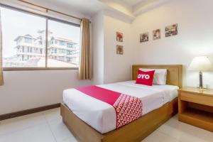 1 dormitorio con 1 cama con almohada roja en Super OYO 1096 Winner Inn Hotel, en Chiang Mai
