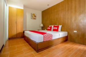 Un dormitorio con una cama con almohadas rojas. en Super OYO 1096 Winner Inn Hotel, en Chiang Mai